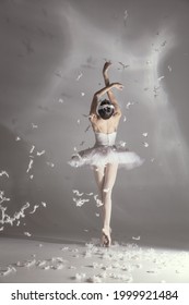 Dance On The Tips Of Toes. Young Graceful Tender Woman, Balerina In Image Of White Swan With Feathers In Art Performance Isolated On White Background. Back View