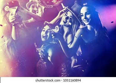 Dance party group people dancing. Women and men have fun in night club. Rest after hard day at work. Back light on girls hair. People dance under influence of alcohol. Toning and blur for background. - Shutterstock ID 1051160894