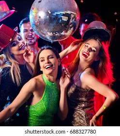 Dance Party With Group People Dancing. Women And Men Have Fun In Night Club. Happy Girl On Foreground And Disco Ball On Background. Guys Took Off Their Hats. Opening A New Strip Club.