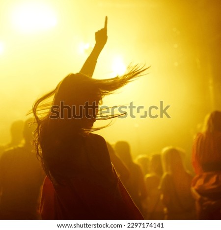 Dance, rave and female person at a concert, disco event or psychedelic trance festival. Night, energy and woman dancing or moving to a song with a yellow light at techno night club or party with dj.