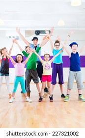 Dance Teacher Giving Children Zumba Fitness Class In Gym