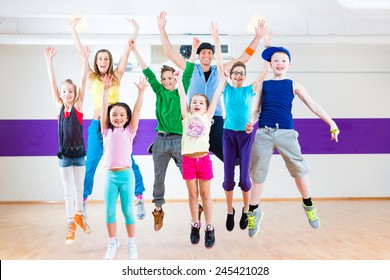 Dance teacher giving children Zumba fitness class in gym