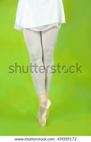  dancer in ballet shoes dancing in pointe over green
