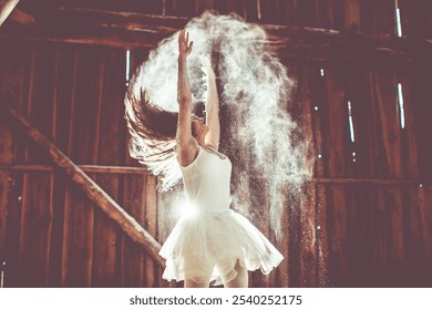 A dancer gracefully leaps in a rustic barn, surrounded by a cloud of dust and illuminated by a warm spotlight, capturing the raw energy and freedom of the moment