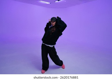 Dancer performs stylish moves in a vibrant studio with purple lights