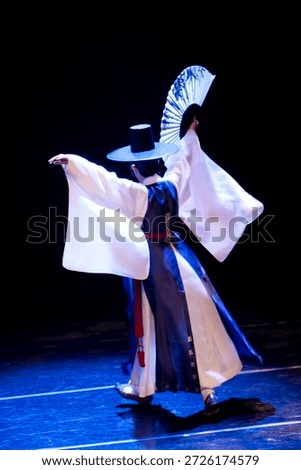Dancer performs traditional Korean dance on stage during cultural event in the evening