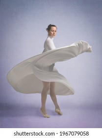 Dancer in a white dress twirls around as the skirt flutters with the movement