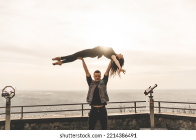 Dancers Couple Posing An Acrobatic Lift On A Cliff At Sunset Kissed By The Sun