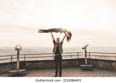 Dancers Couple Posing An Acrobatic Lift On A Cliff At Sunset Kissed By The Sun