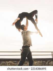 Dancers Couple Posing An Acrobatic Lift On A Cliff At Sunset Kissed By The Sun