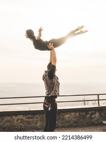 Dancers Couple Posing An Acrobatic Lift On A Cliff At Sunset Kissed By The Sun