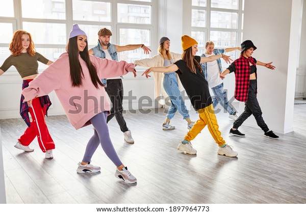 dancers performing modern dance element, preparing\
for concert in studio, professional group of young dancers\
practicing moves