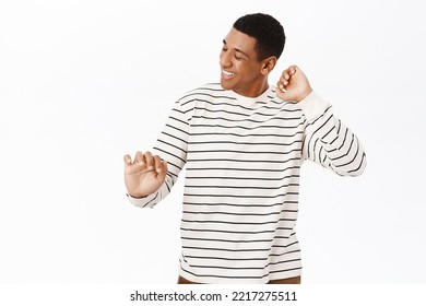 Dancing African American Man Having Fun, Smiling Pleased, Posing Over White Background In Casual Clothes