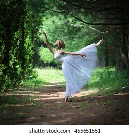 Dancing ballerina in the summer garden. In arabesque pose - Powered by Shutterstock