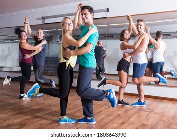 Dancing couples learning swing at dance class