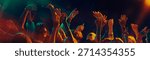 Dancing crowd silhouettes under dramatic concert lighting. Concept of shared emotions, rhythmic movement, social connection, music immersion and Christmas night celebration atmosphere. Banner