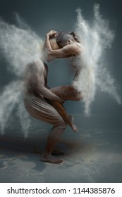 Dancing In Flour Concept. Girl Woman Female Wearing White Dress And Guy Man Male Making Dance Element In Flour / White Dust On Isolated Black / Grey Background. Fairy Butterfly Concept