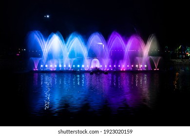 A dancing fountain, or fountain, formed by a controlled ascending and descending rainbow-like lights.  And the color reflecting on the water.