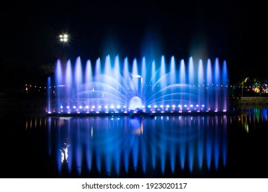 A dancing fountain or a fountain that is formed by controlling the ups and downs and has a light tone bright blue .  And the color reflecting on the water.