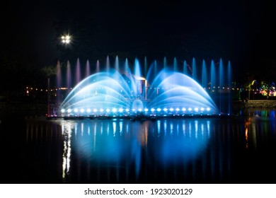 A dancing fountain or a fountain that is formed by controlling the ups and downs and has a light tone bright blue .  And the color reflecting on the water.