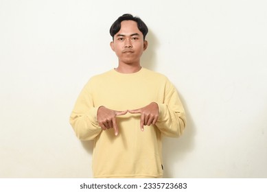 dancing gesture viral on social media Indonesian man wearing yellow sweater on isolated white background. disc jokey gesture. Asians dancing to "If We Ever Broke Up" - Shutterstock ID 2335723683