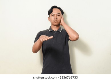 dancing gesture viral on social media Indonesian man wearing black shirt on isolated white background. disc jokey gesture. Asians dancing to "If We Ever Broke Up" - Shutterstock ID 2336768733