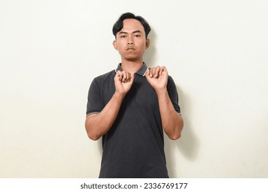 dancing gesture viral on social media Indonesian man wearing black shirt on isolated white background. disc jokey gesture. Asians dancing to "If We Ever Broke Up" - Shutterstock ID 2336769177