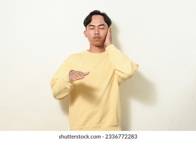 dancing gesture viral on social media Indonesian man wearing yellow sweater on isolated white background. disc jokey gesture. Asians dancing to "If We Ever Broke Up" - Shutterstock ID 2336772283