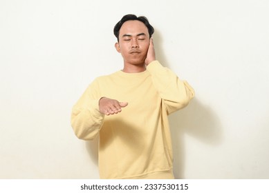 dancing gesture viral on social media Indonesian man wearing yellow sweater on isolated white background. disc jokey gesture. Asians dancing to "If We Ever Broke Up" - Shutterstock ID 2337530115