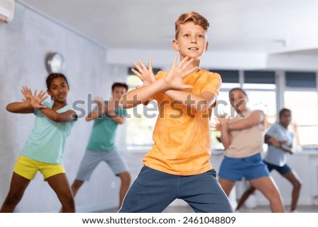Dancing group of five children practicing new dance in studio
