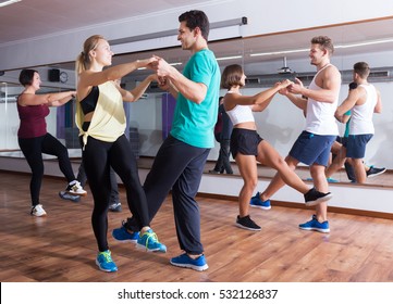 Dancing Happy Young Couples Learning Swing At Dance Class