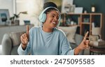 Dancing, music and black woman with headphones in home with streaming hip hop playlist and online radio for sound. African person, gen z girl and happy singing with listening to rap song for fun
