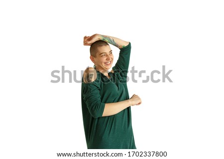 Dancing. Portrait of young caucasian woman with freaky appearance on white background. Unusual look with tattoos and bald. Human emotions, facial expression,sales, ad concept. Youth culture.