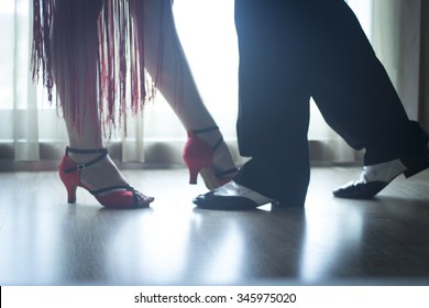 Dancing shoes feet and legs of female and male couple ballroom and latin salsa dancer dance teacher in dance school rehearsal room class.