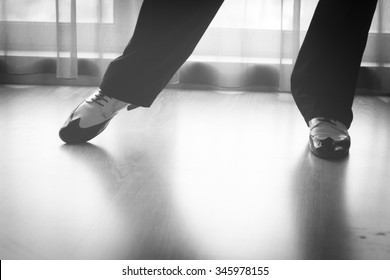 Dancing shoes feet and legs of male ballroom and latin salsa dancer dance teacher in dance school rehearsal room class.