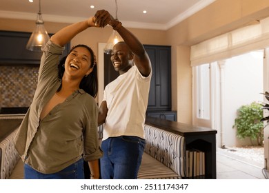 Dancing together, happy multiracial couple enjoying quality time in modern home kitchen. happiness, love, lifestyle, togetherness, domestic - Powered by Shutterstock