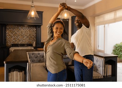 Dancing together in kitchen, multiracial couple enjoying quality time at home. Romantic, lifestyle, happiness, togetherness, bonding, domestic - Powered by Shutterstock