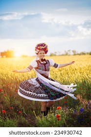 Dancing Woman In The Field. She Is Wearing Traditional Eastern Europe Folk Costumes.