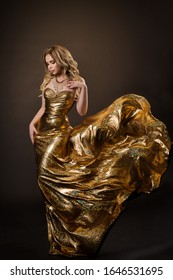 Dancing Woman In Gold Dress Flying On Wind, Beautiful Lady In Fluttering Sparkling Golden Gown