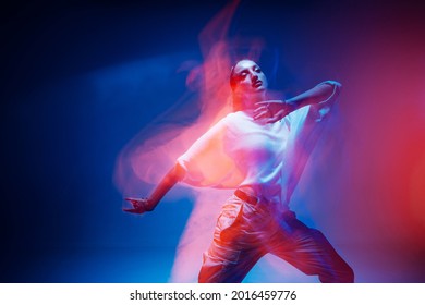 Dancing Young Mixed Race Girl Enjoying Moving In Colorful Neon Studio Light. Long Exposure. Ethnic Fiery Dance