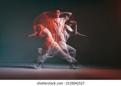 Dancing young sporty girl moving in fiery hip-hop dance in red neon studio light. Long exposure. Breakdancing school ad - Shutterstock ID 2133042527