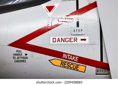 Danger Aircraft Jet Ejector Seat Rescue And Intake Signs On Side Of Modern Military Airforce Plane.