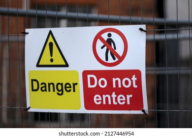 Danger Do Not Enter Sign On Fence Around Old Building