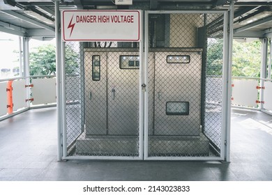 Danger High voltage sign symbol on metal cabinet electric control cover in fence on skyway.