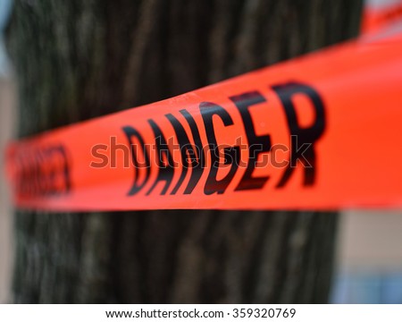 Danger Red Tape Warning in front of a tree/ Red Danger sign Tape