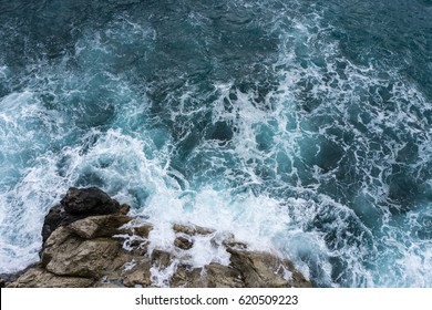 Danger sea wave crashing on rock coast with spray and foam before storm in Positano, Italy