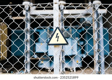 Danger sign, high voltage, on the fence of an electrical transformer.