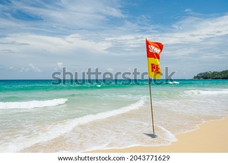 Danger for swimming red flag on beach.Caution sign that tourists  on the beach.Landscape clean sea white clouds soft daylight.Blue sea waves and sky on sand beach.