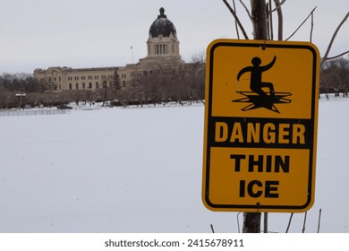 Danger thin ice warning sign on the background of the Saskatchewan Legislative Building. Frozen Wascana Lake in the city of Regina - Powered by Shutterstock