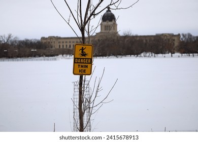 Danger thin ice warning sign on the background of the Saskatchewan Legislative Building. Frozen Wascana Lake in the city of Regina - Powered by Shutterstock